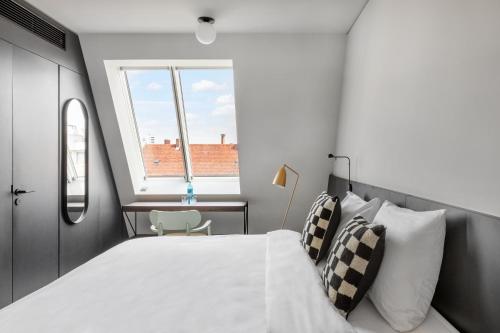 numa I Savi Rooms & Apartments في برلين: غرفة نوم بسرير ابيض كبير ونافذة
