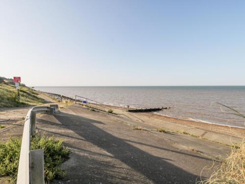 a road leading to the ocean with a pier at Amazing Cottage in Sheerness