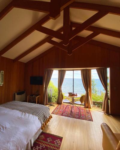 1 dormitorio con cama y vistas al océano en Cabañas Bahia Celeste, Puerto Varas, en Puerto Varas