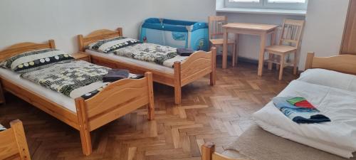 a room with three beds and a table and chairs at Ubytovanie Topoľčany in Topoľčany
