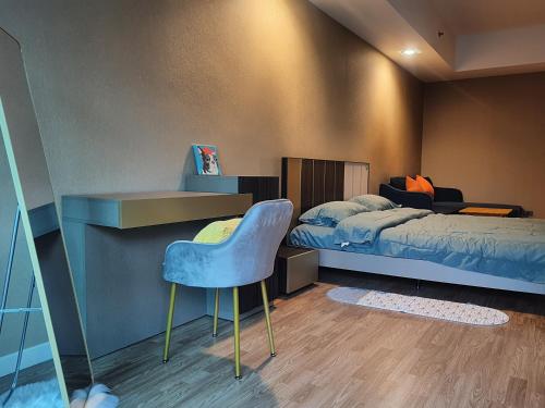 1 dormitorio con 1 cama y 1 silla azul en Baan Nonzee Condo en Bangkok