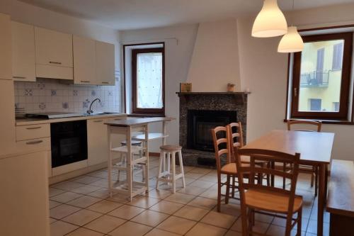 une cuisine avec une table et des chaises ainsi qu'une cheminée dans l'établissement Casa Vacanze Boletus sul lago, à Claino
