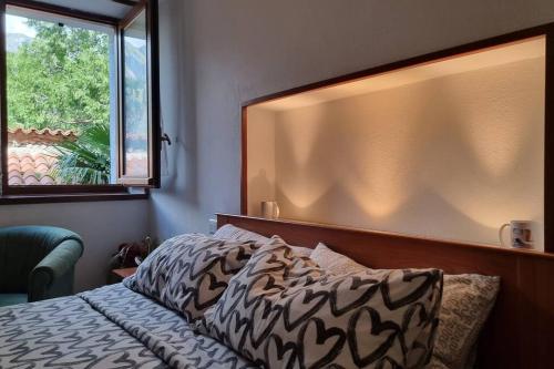 - une chambre avec un lit, une fenêtre et un couvre-lit dans l'établissement Casa Vacanze Boletus sul lago, à Claino