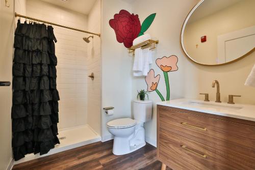 a bathroom with a toilet and a sink and a mirror at Urban Collective Boutique Hotel in Edwardsville