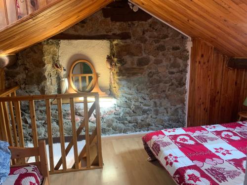 a bedroom with a bed and a stone wall at Joli appartement dans une maison ancienne in Ax-les-Thermes