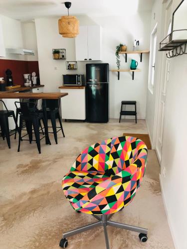 une chaise colorée dans une chambre avec cuisine dans l'établissement CASA DAHLIA - Charmant appartement équipé avec grande terrasse, à Marseillan
