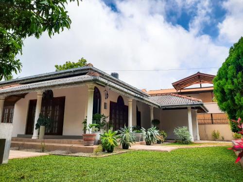 a house with a lawn in front of it at Marette Holiday Bungalow in Moratuwa