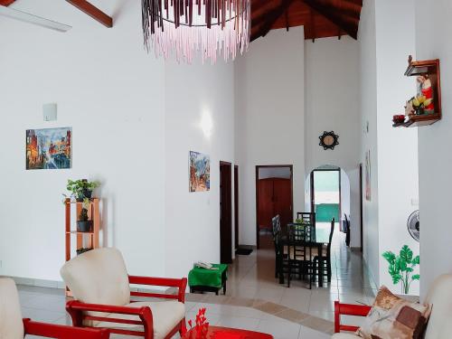 a living room with white walls and a chandelier at Marette Holiday Bungalow in Moratuwa