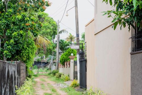 an alley with a dirt road between two buildings at Marette Holiday Bungalow in Moratuwa