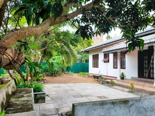 a courtyard in front of a house with a tree at Marette Holiday Bungalow in Moratuwa