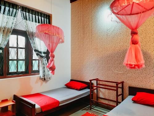 two beds in a room with red and white curtains at Marette Holiday Bungalow in Moratuwa