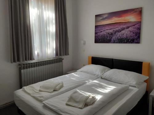 ein weißes Bett mit zwei weißen Handtüchern darauf in der Unterkunft Grand Bells Bed And Breakfast in Zagreb