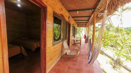 a porch of a wooden house with a chair at El Retiro Lanquin in Lanquín