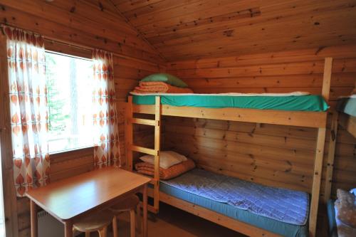 a cabin with two bunk beds and a table at Hännilänsalmi Camping in Viitasaari