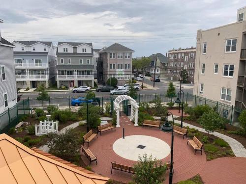 a park in a city with benches and buildings at Beach Block Condo in Ventnor City