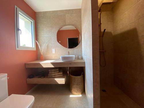 W łazience znajduje się umywalka i lustro. w obiekcie La Musardise Guest House w mieście Berson
