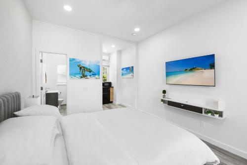 a white bedroom with a white bed and a tv at The Hotel Deauville in Fort Lauderdale