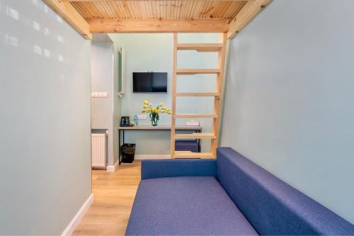 a living room with a blue couch and a desk at JESS INN Hostel Rondo Charles de Gaulle in Warsaw