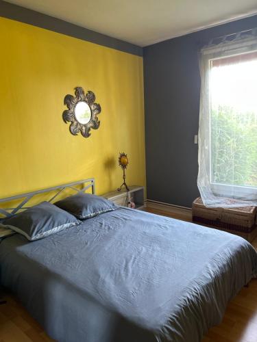 a bedroom with a blue bed and a window at Chambre d’hôtes avec piscine in Éguzon-Chantôme