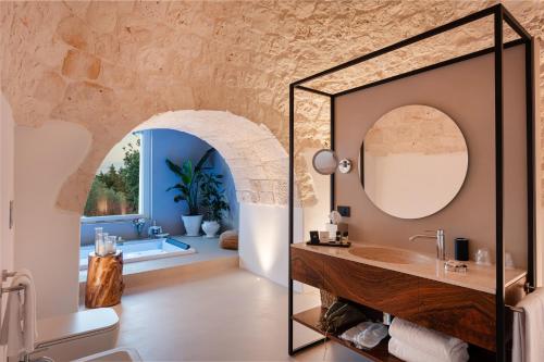 a bathroom with a sink and a mirror at Essenza Relais Contemporaneo in Cisternino
