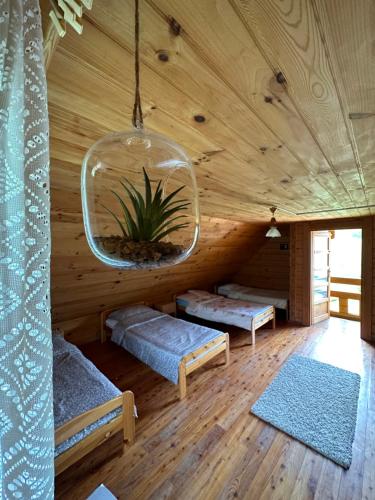 a room with two beds in a wooden house at Domki letniskowe Stary dąb in Solina