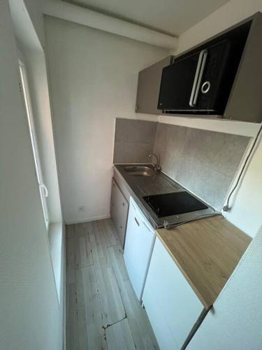 a small kitchen with a sink and a stove at Studio proche La Defense in Puteaux