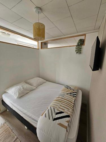 um pequeno quarto com uma cama e uma televisão em APPARTEMENT COTE D'OPALE em Boulogne-sur-Mer