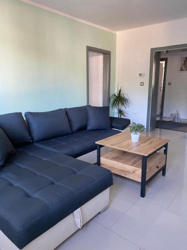 a living room with a blue couch and a coffee table at Gatto in Jajce