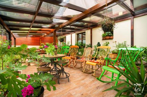 un patio avec des tables, des chaises et des plantes dans l'établissement Art'e Boutique Hotel, à Băile Tuşnad