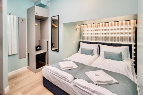 1 dormitorio con 1 cama grande y 2 toallas. en JESS INN Hostel Rondo Charles de Gaulle en Varsovia