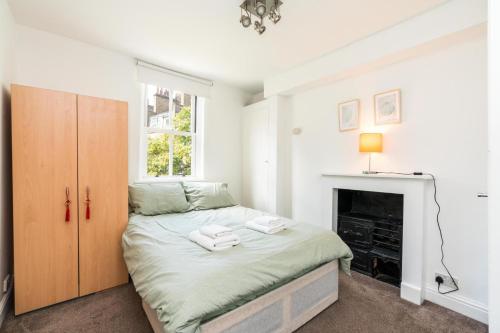 a bedroom with a bed and a fireplace at Super 1BD Flat minutes from Kings Cross Station in London