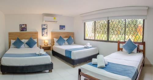 卡塔赫纳Casa Franco Hotel的有两张床和一扇窗户的卧室
