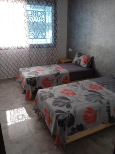サイディアにあるAppartement Saidia a 500 m de la plage LOT Orange 3のベッド2台と窓のある寝室