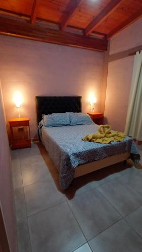 1 dormitorio con 1 cama y 2 lámparas en 2 mesas en Los jacaranda en Cruz de Caña