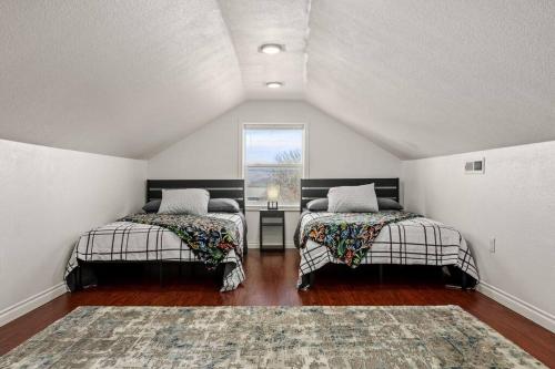 a attic room with two beds and a window at Large Fenced Yard and Outdoor Patio in Lewiston