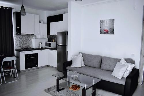 uma sala de estar com um sofá e uma cozinha em Etalon Airport Apartments em Otopeni