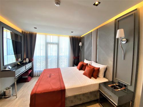 een slaapkamer met een groot bed met rode kussens bij Atar Airport Hotel in Arnavutköy