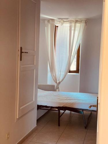 un lit dans une chambre avec une fenêtre dans l'établissement Appartement cosy T2 - 4 personnes -proche de la mer, à Marseille