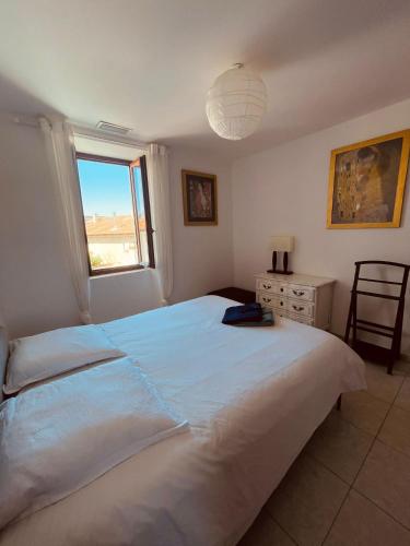 - une chambre avec un grand lit blanc et une fenêtre dans l'établissement LOCATION TYPE T2 – APPARTEMENT – 4 COUCHAGES, à Marseille