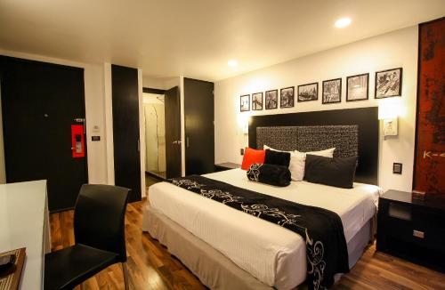 a bedroom with a large bed and a chair at Hotel Black Boutique in Mexico City