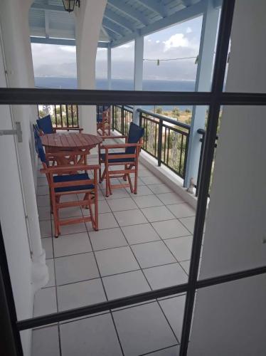 a balcony with a table and chairs and a view of the ocean at The Captain in Elafonisos