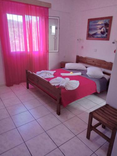 a bedroom with two beds and a red blanket at The Captain in Elafonisos