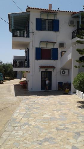 a large white building with a person standing in front of it at The Captain in Elafonisos
