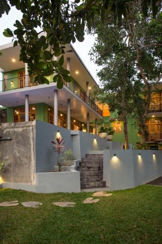 a building with a staircase in front of it at Barefoot Bungalow Hikka in Hikkaduwa