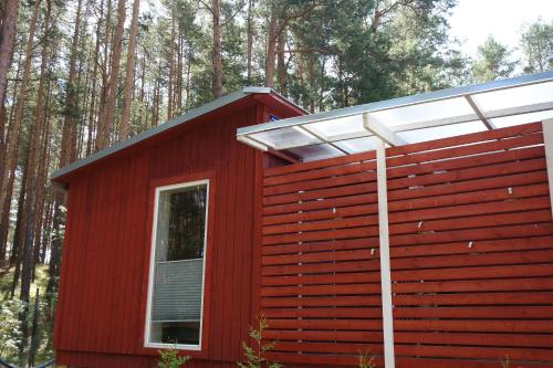 uma cabina vermelha com uma janela e um telhado em Holiday home near sea beach & pine forest em Riga