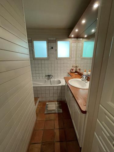 une salle de bain avec une baignoire et un lavabo dans l'établissement Cosy Chalet Annecy Lake for a family, à Sévrier