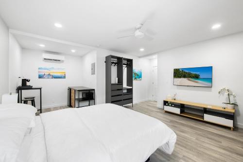 a white bedroom with a large white bed and a desk at The Hotel Deauville in Fort Lauderdale