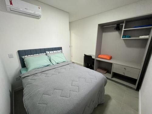 - une chambre avec un grand lit et un bureau dans l'établissement Apartamento amplo e bem decorado, à Governador Celso Ramos