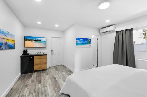 a white bedroom with a bed and a dresser at The Hotel Deauville in Fort Lauderdale