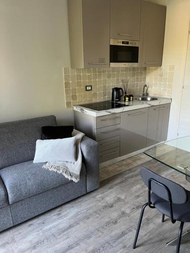 a living room with a couch and a kitchen at Garda Flow Holiday Home in Lonato del Garda